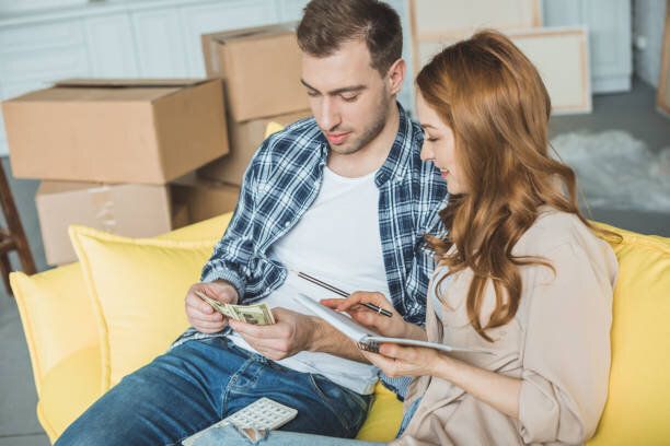 若いカップル ノートとホームを移動しながらお金を数える