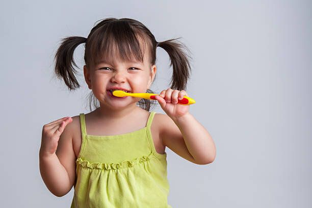 若い女の子歯みがきにイエローの歯ブラシ