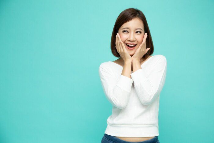 緑色の背景に孤立した若いアジアの女性の興奮した叫び声の肖像画、うわーと驚いたコンセプト