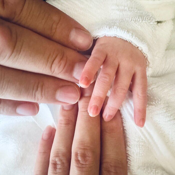 お子さんのかわいらしい小さな手と、真風さん、勝矢さんの優しい手。