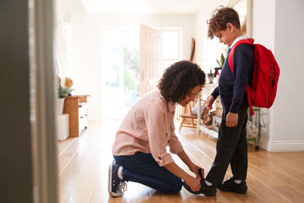 家で独身の母親は、学校の初日の準備ができて息子が制服を着て取得