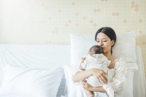 生まれたばかりの赤ちゃんと美しい若いアジアの母の肖像画を間近します。