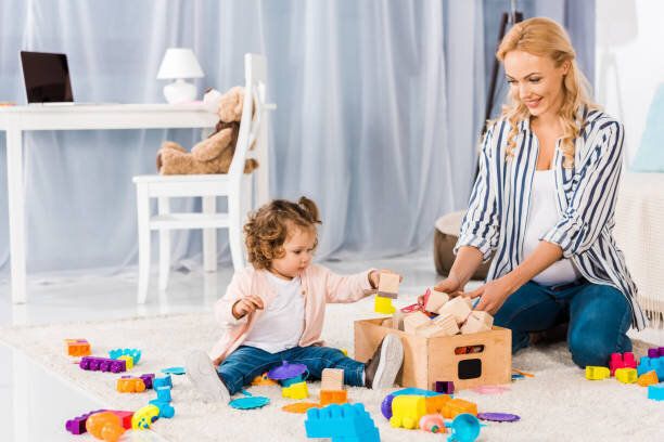 小さな娘と遊んで幸せな妊娠中の母親
