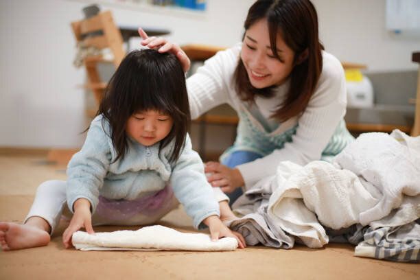 洗濯物を折りたたむのを手伝っている女の子