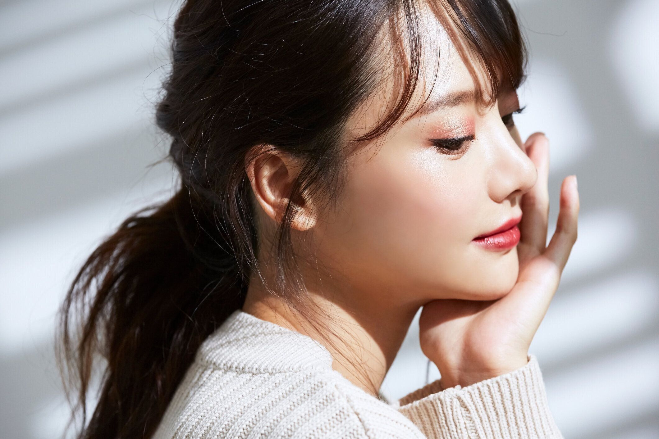 光と影の背景に若いアジアの女性の美の肖像画