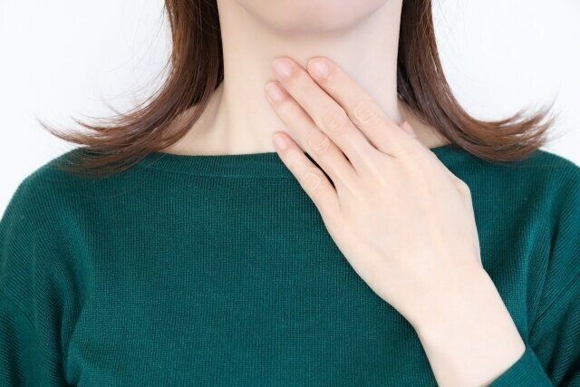 喉を抑える女性