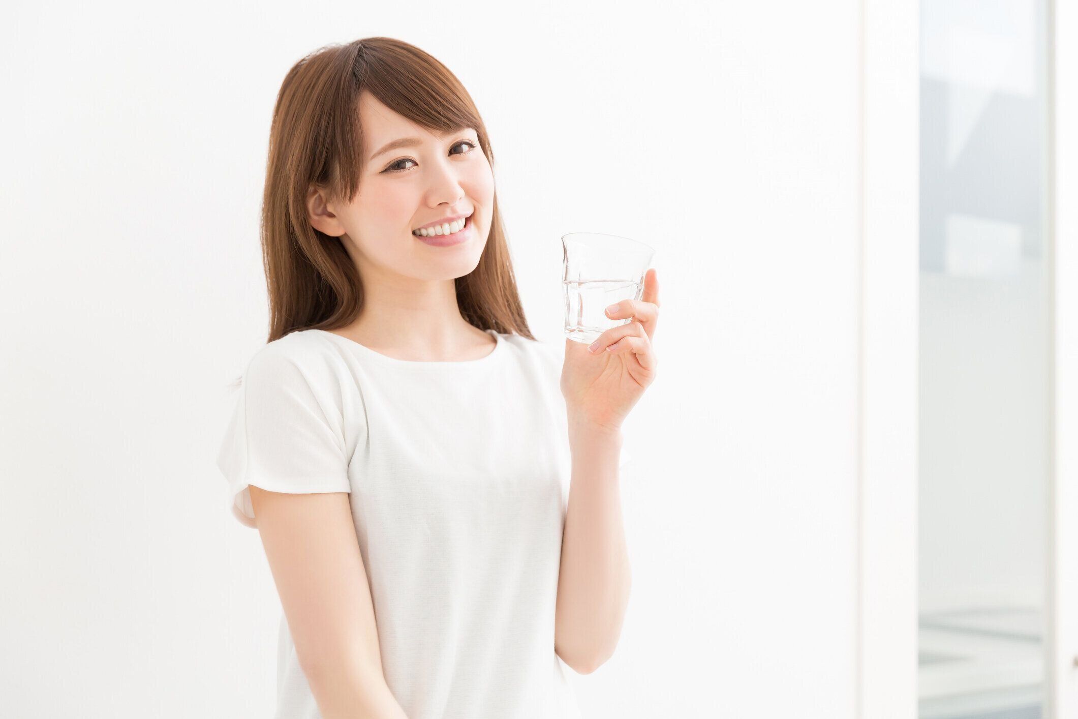 コップ一杯の水を持つ日本人女性