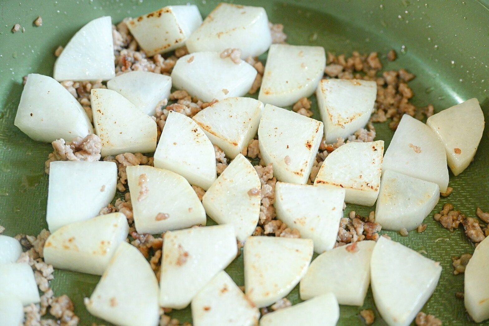 フライパンに入った炒めた大根とひき肉