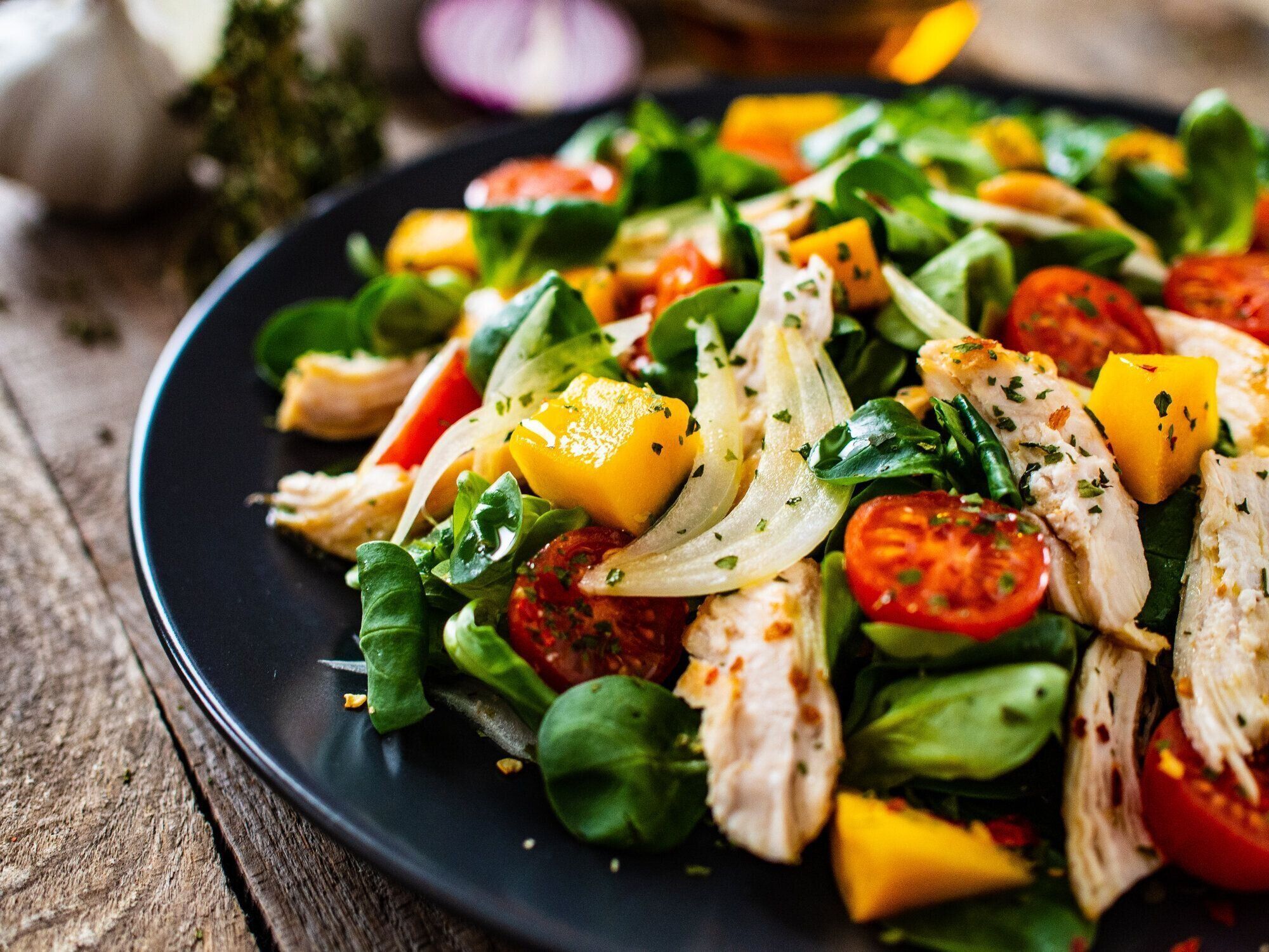 シーザーサラダ - 木製の背景にローストチキン肉と野菜サラダ