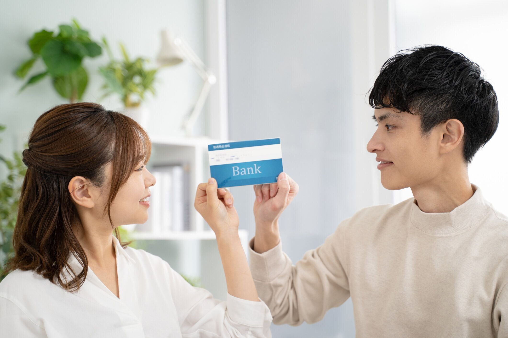 銀行の通帳、夫婦の笑顔と協力