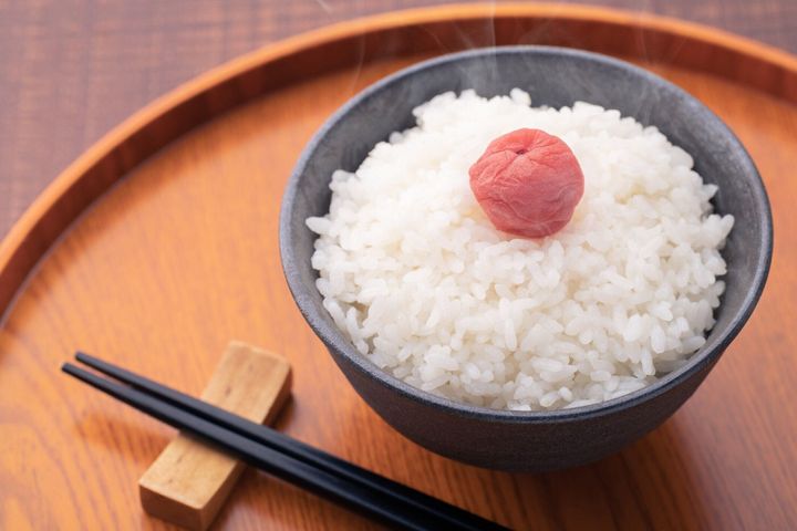 木製のテーブルの上に米と梅の漬け物