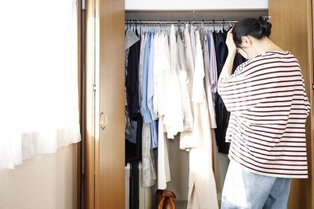 クローゼットの前で悩む女性