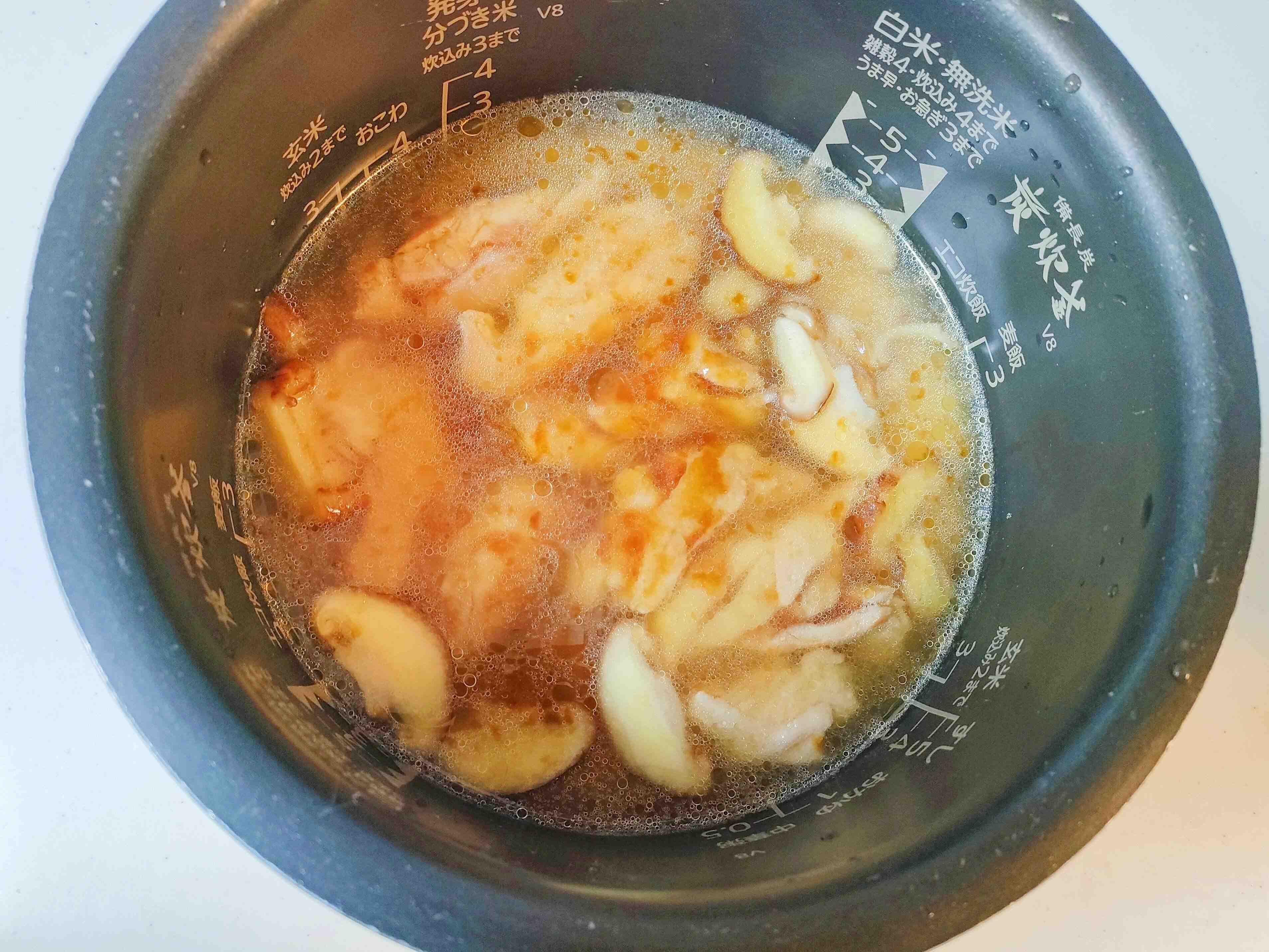 炊飯器の釜にお米と一緒に炒めた鶏肉としいたけをいれる