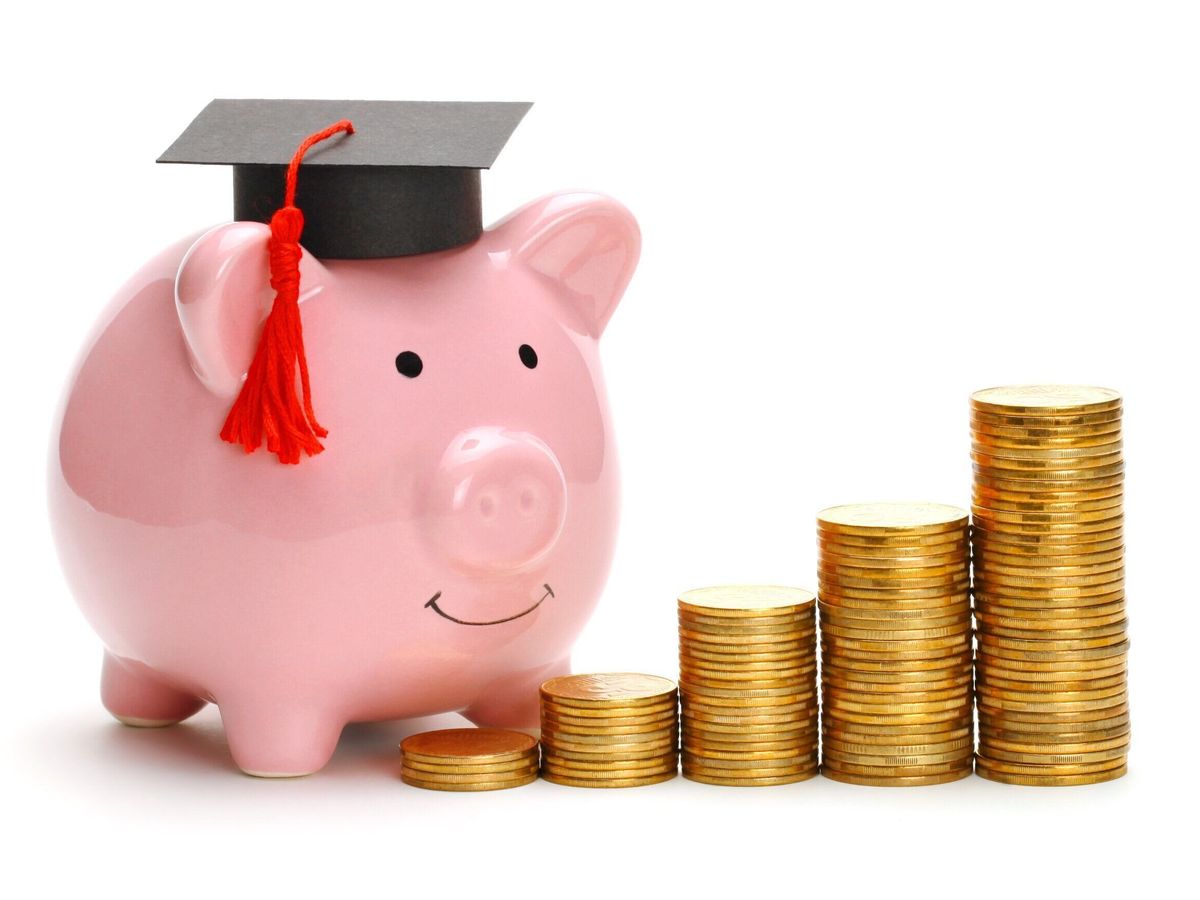 コインのスタックの近くに大学院のキャップで貯金箱