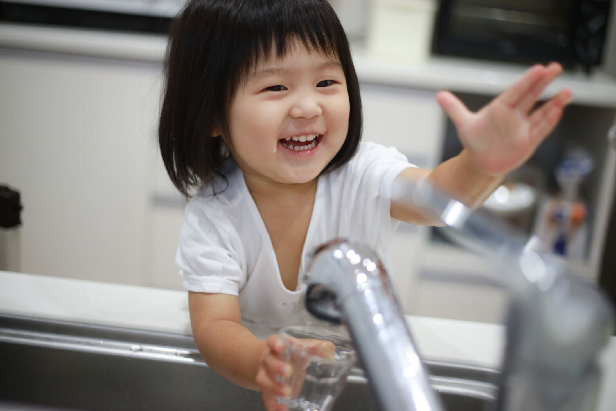 コップに水を注ぐ女の子