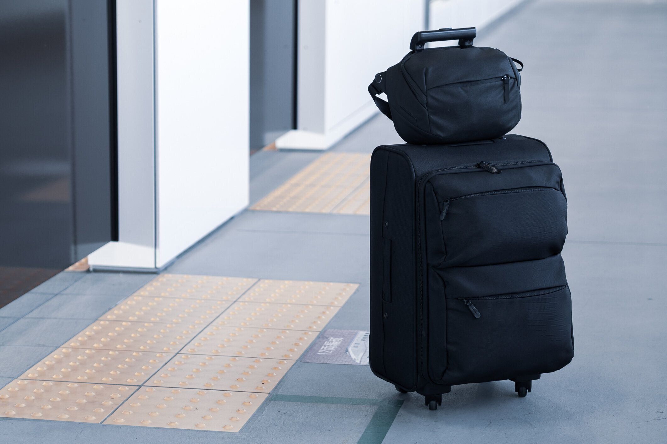 プラットフォームで遅延列車を待っている荷物のキャリーします。