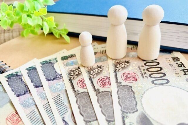 お札の上にのった人型の積み木