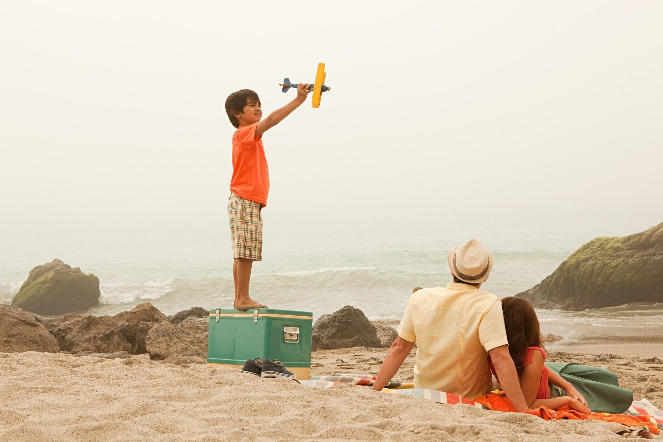 ご家族のビーチで遊ぶ少年トーイ面