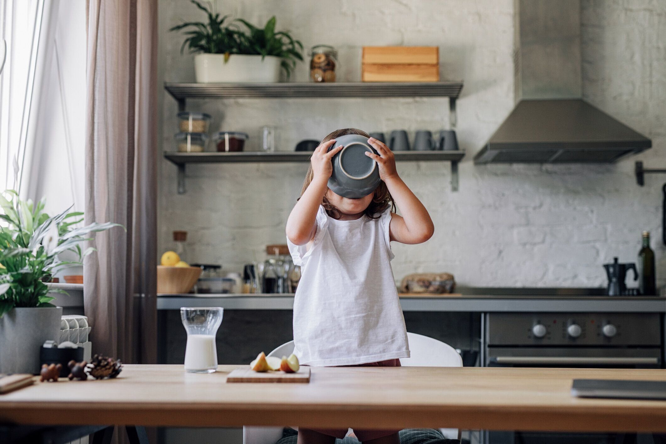 ダイニングルームで朝食にシリアルを食べるハッピーヤングガール