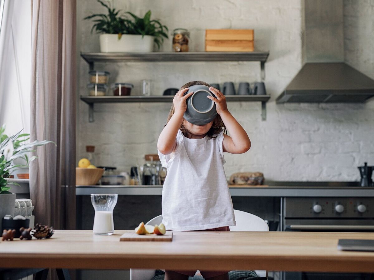 ダイニングルームで朝食にシリアルを食べるハッピーヤングガール
