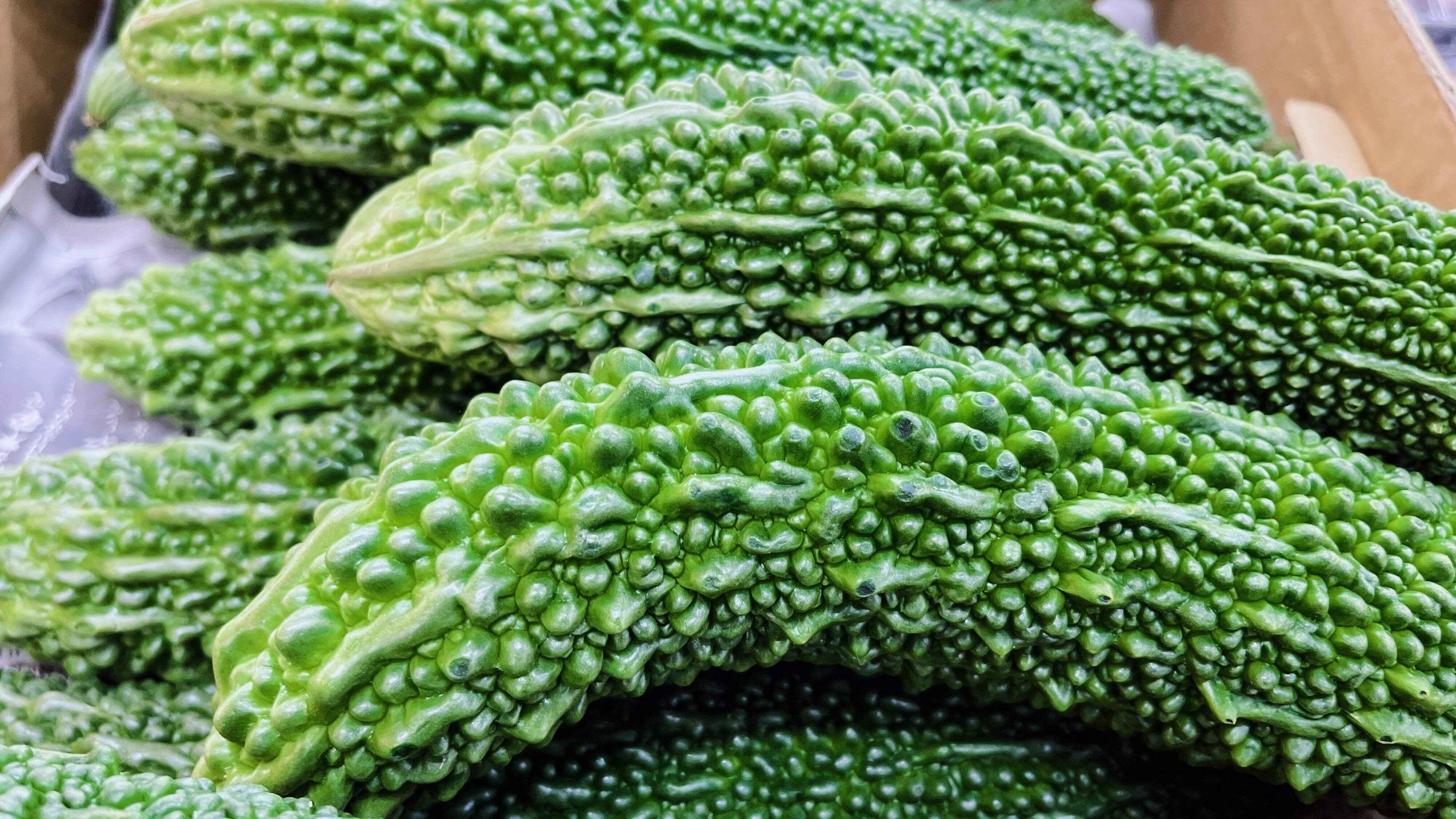 ファーマーマーケットの不機嫌そうなゴーヤのテクスチャーのクローズアップ