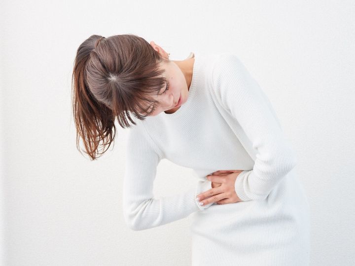 腹痛を持つアジアの女性