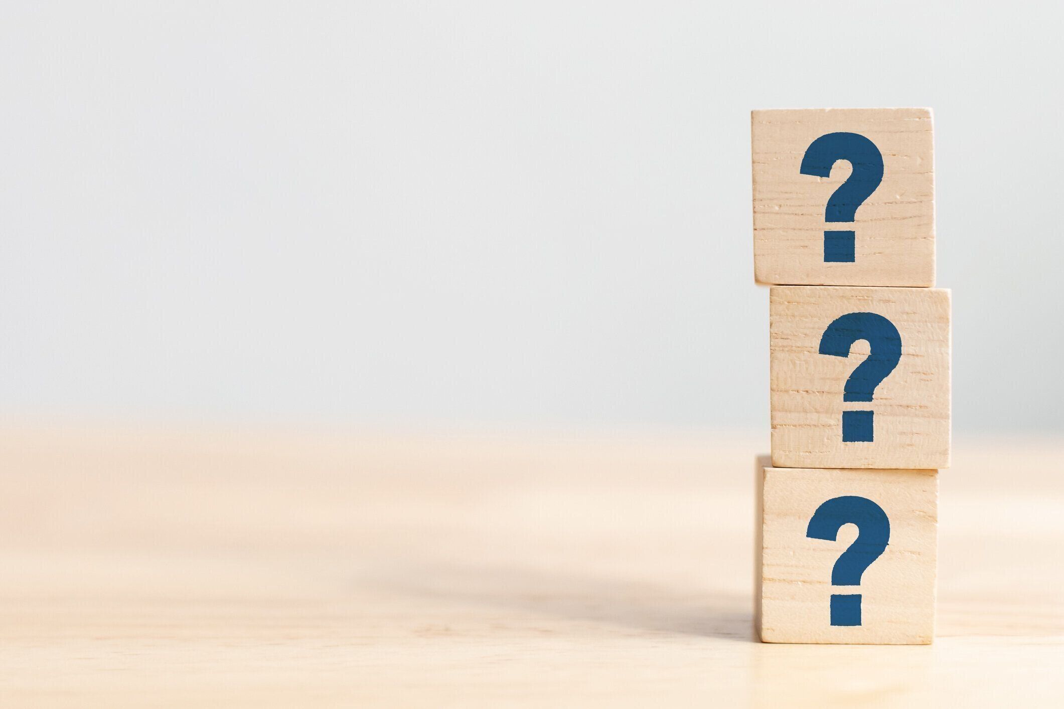 木製のテーブルに記号の疑問符記号が付いている木製の立方体のブロックの形