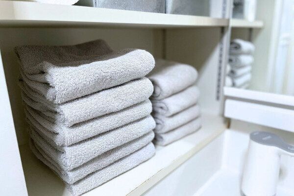 色とサイズが揃ったタオルが並ぶ、スッキリした脱衣所