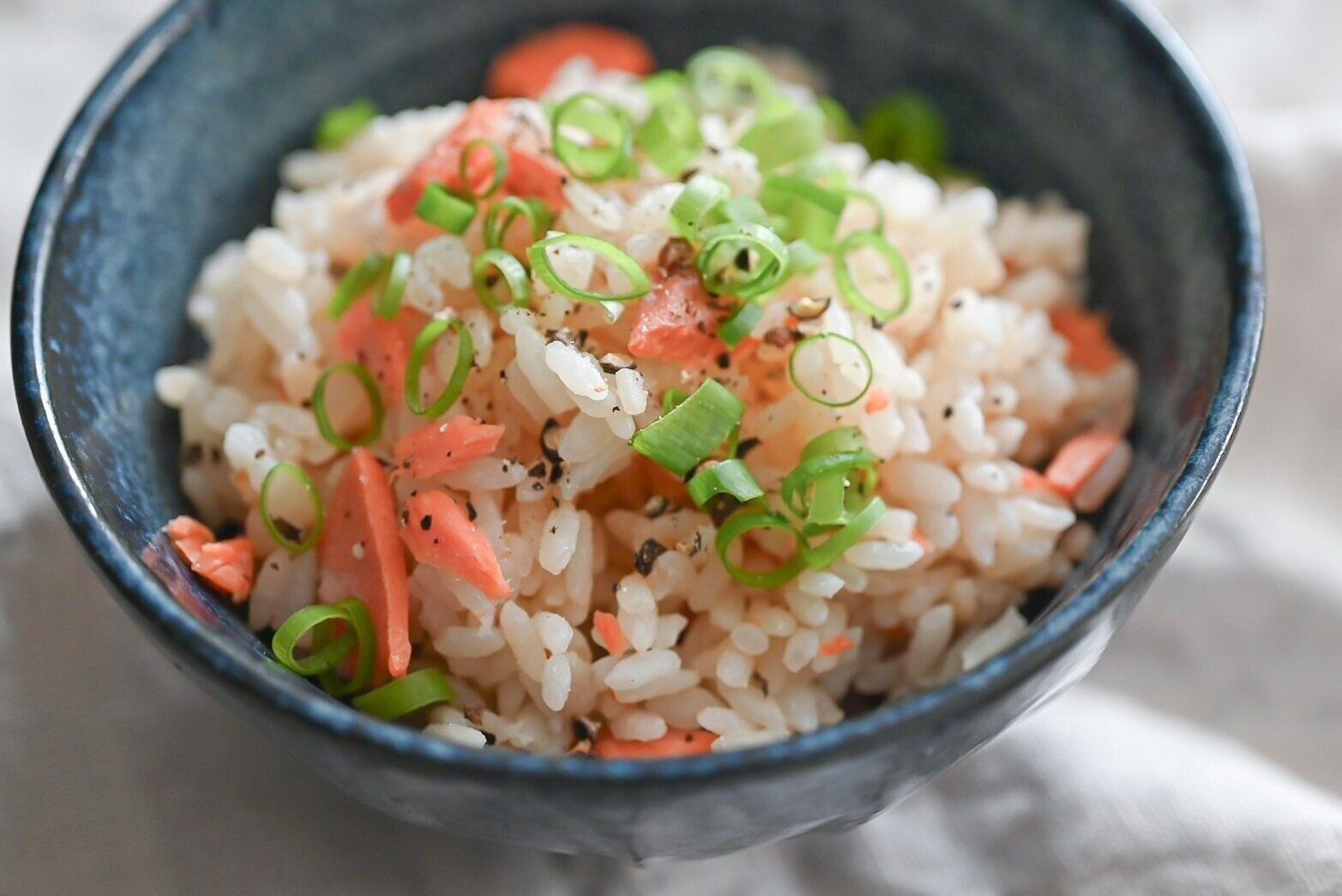青い茶碗に入った鮭バター炊き込みごはん