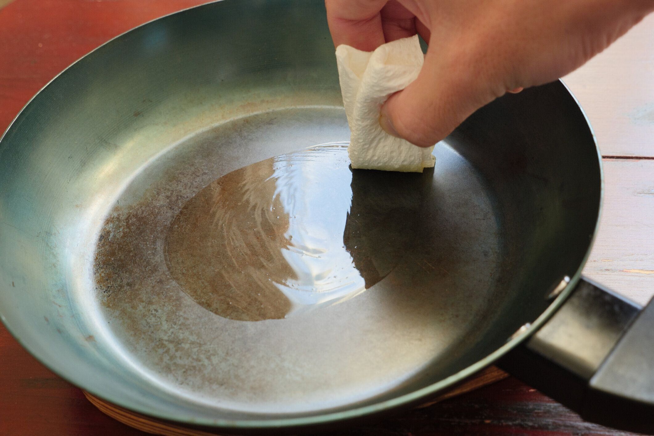 メンテナンスのためにオリーブオイルを鉄のスキレットに塗布する