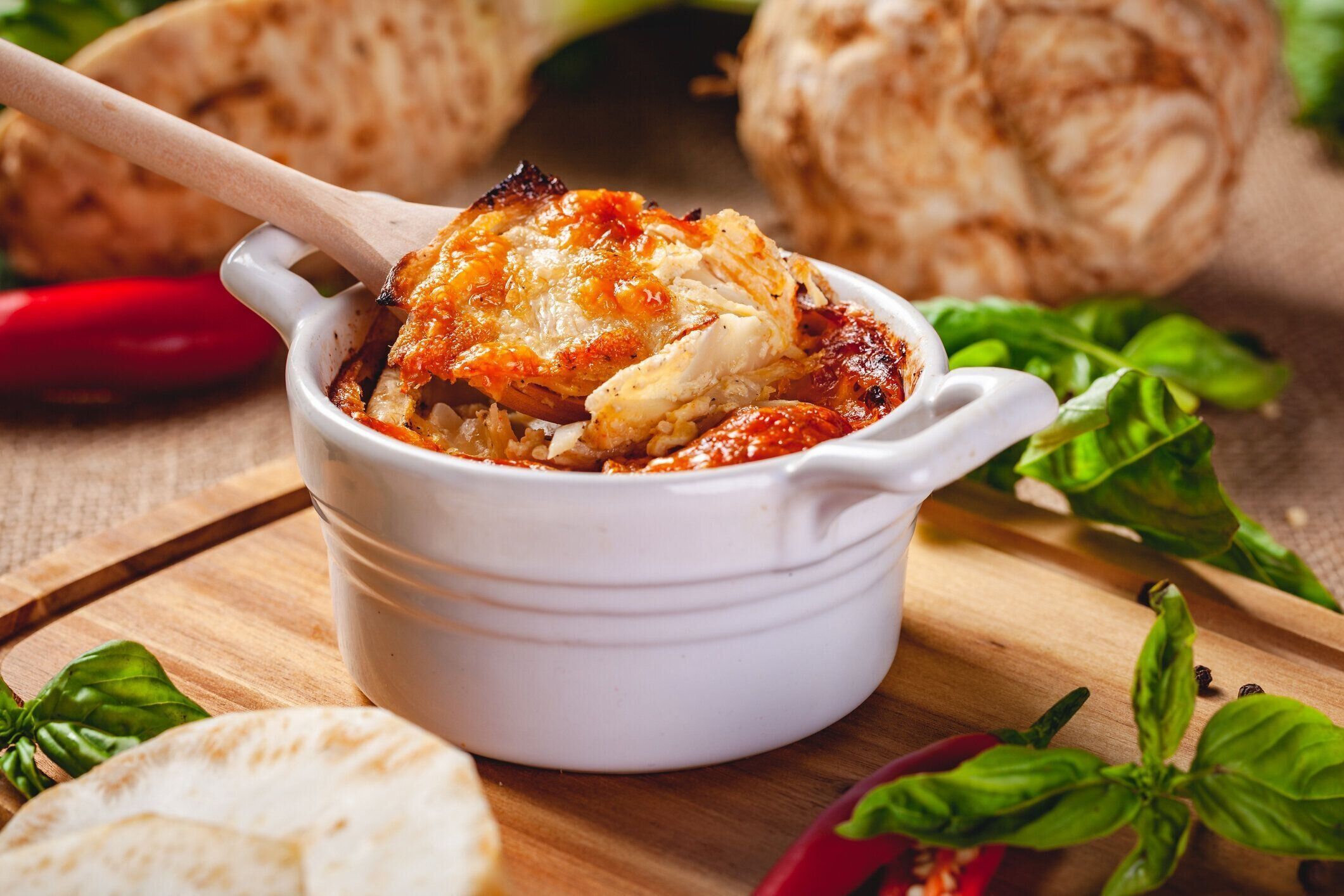 木製のボード上のチーズとキノコとセロリの根グラタン。クローズアップ