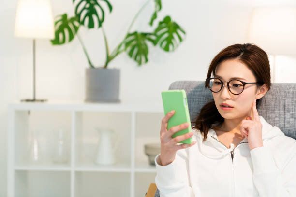 スマートフォンを見るためにアジアの女性は、考える、