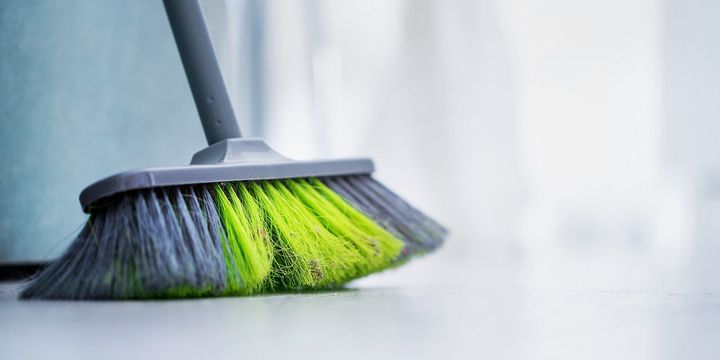 緑の髪の大きなほうきは、クリーニングルームのための木製のオフィスやホームフロアに立っています