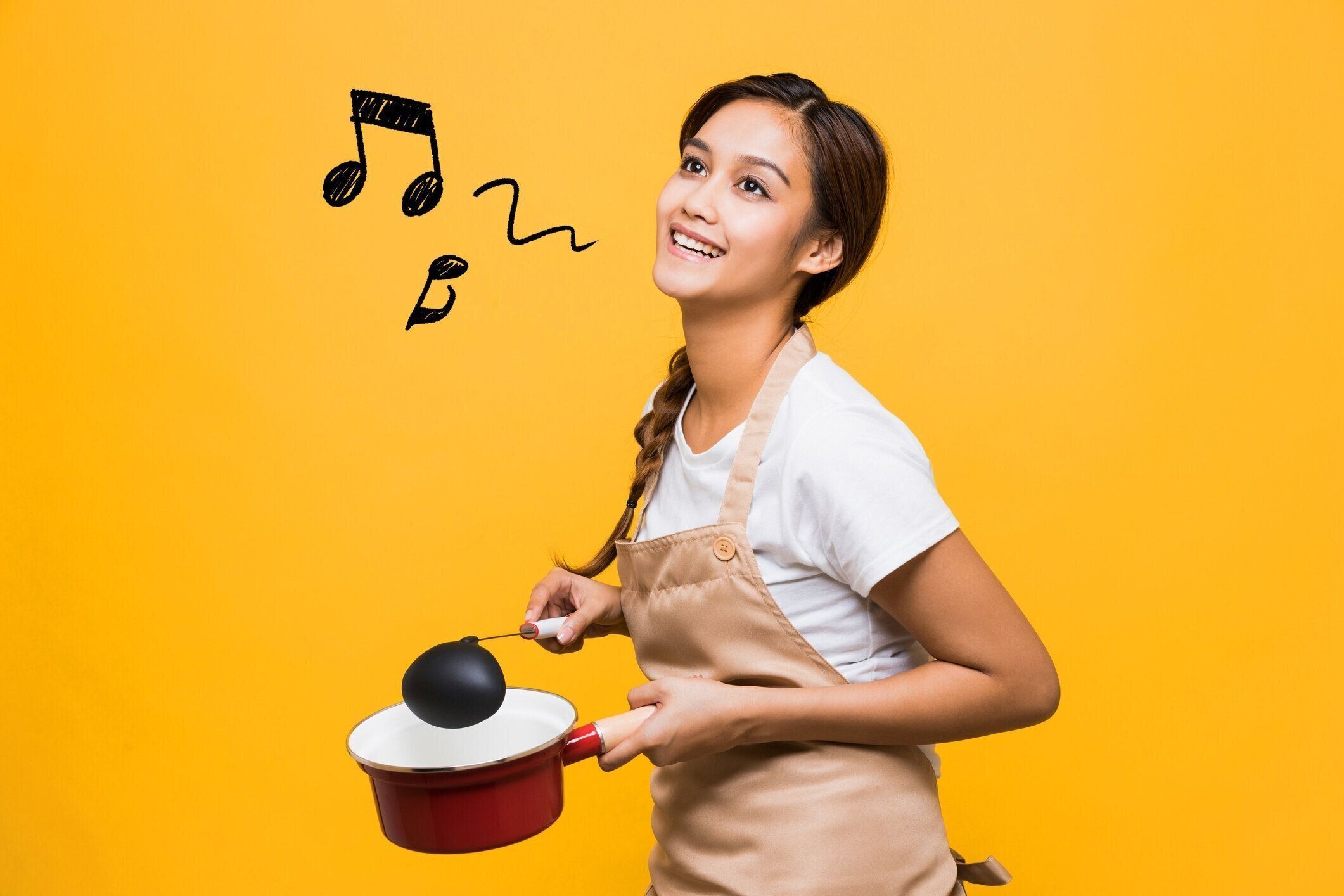 鍋とお玉を保持している若い女性。