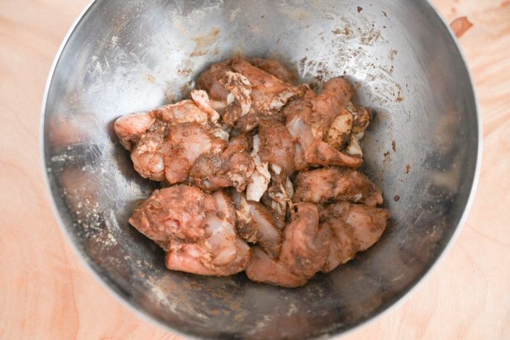 ボウルに入ったマリネシーズニングと和えたもも肉