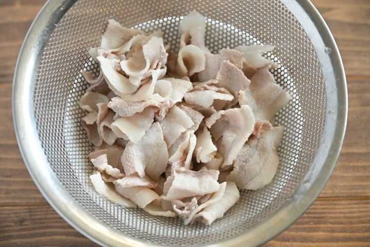ざるに入ったゆでた豚バラ肉