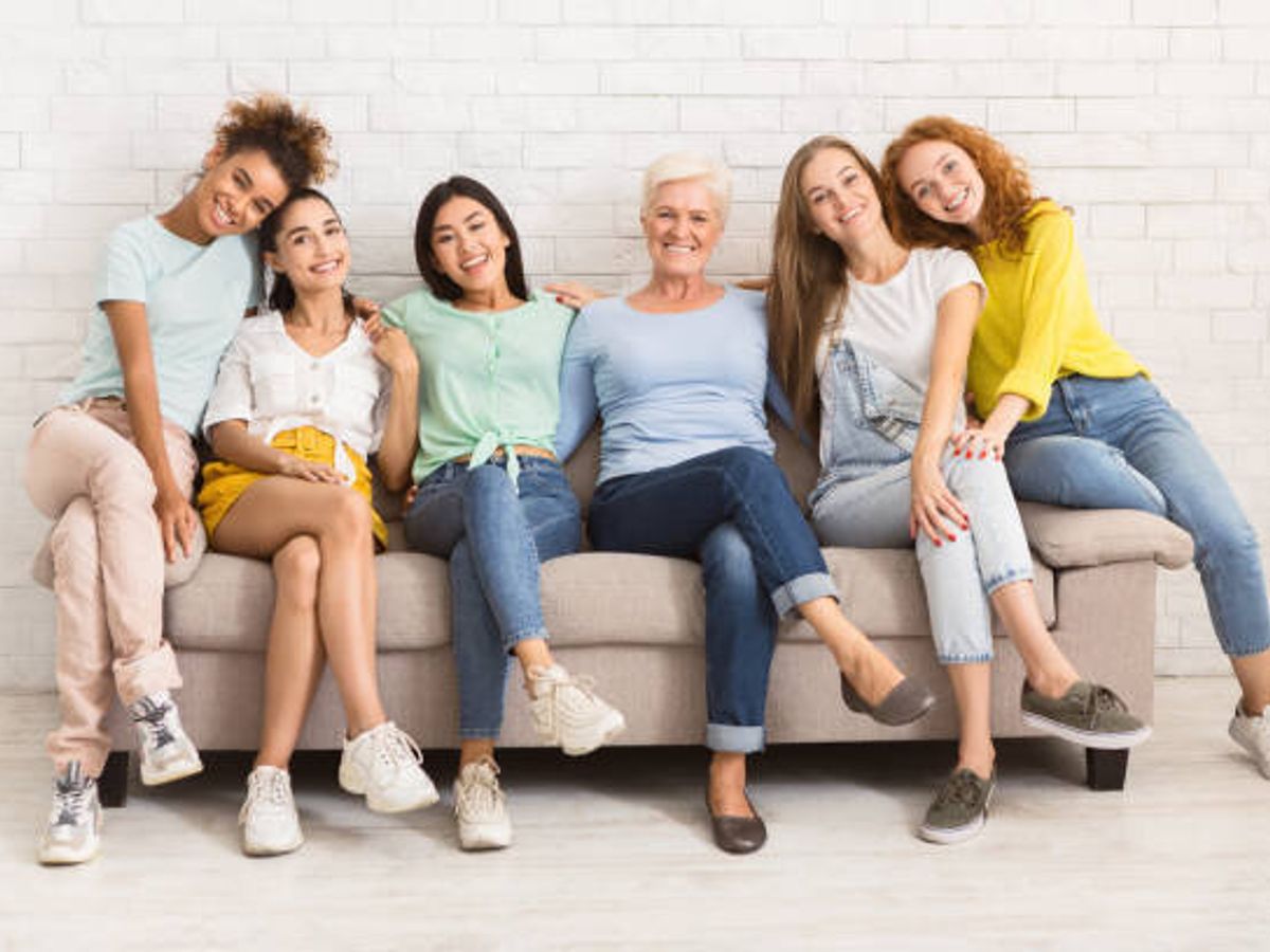 屋内で微笑むソファに座っている異なる年齢の女性