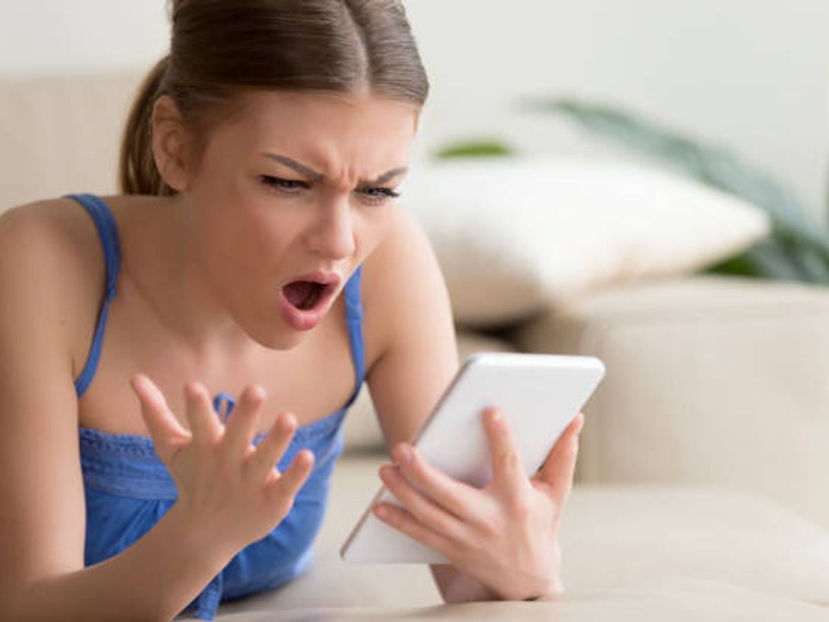 家庭でデジタル タブレットを使用してショックを受けた若い女性