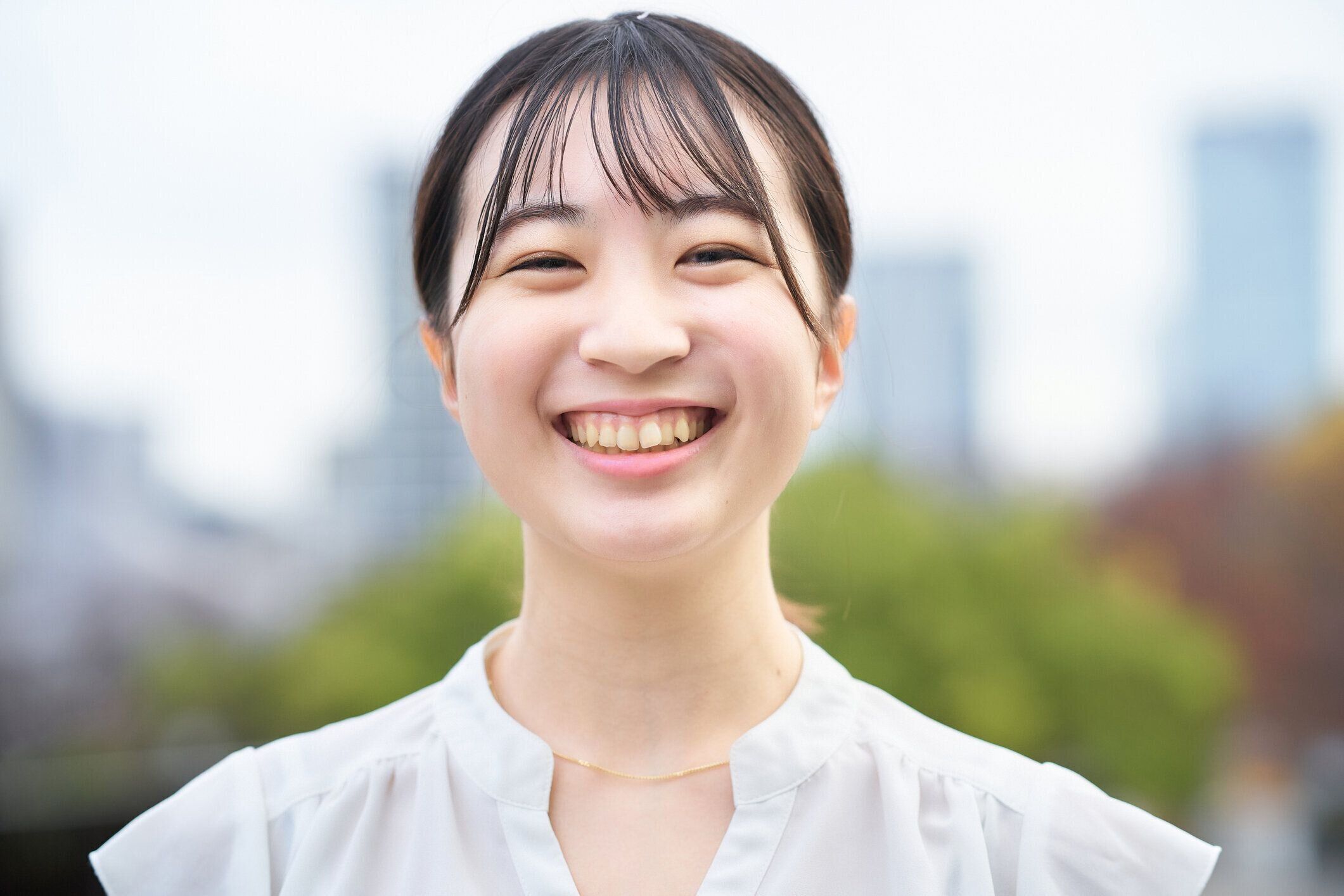 屋外で微笑むアジアの若い女性