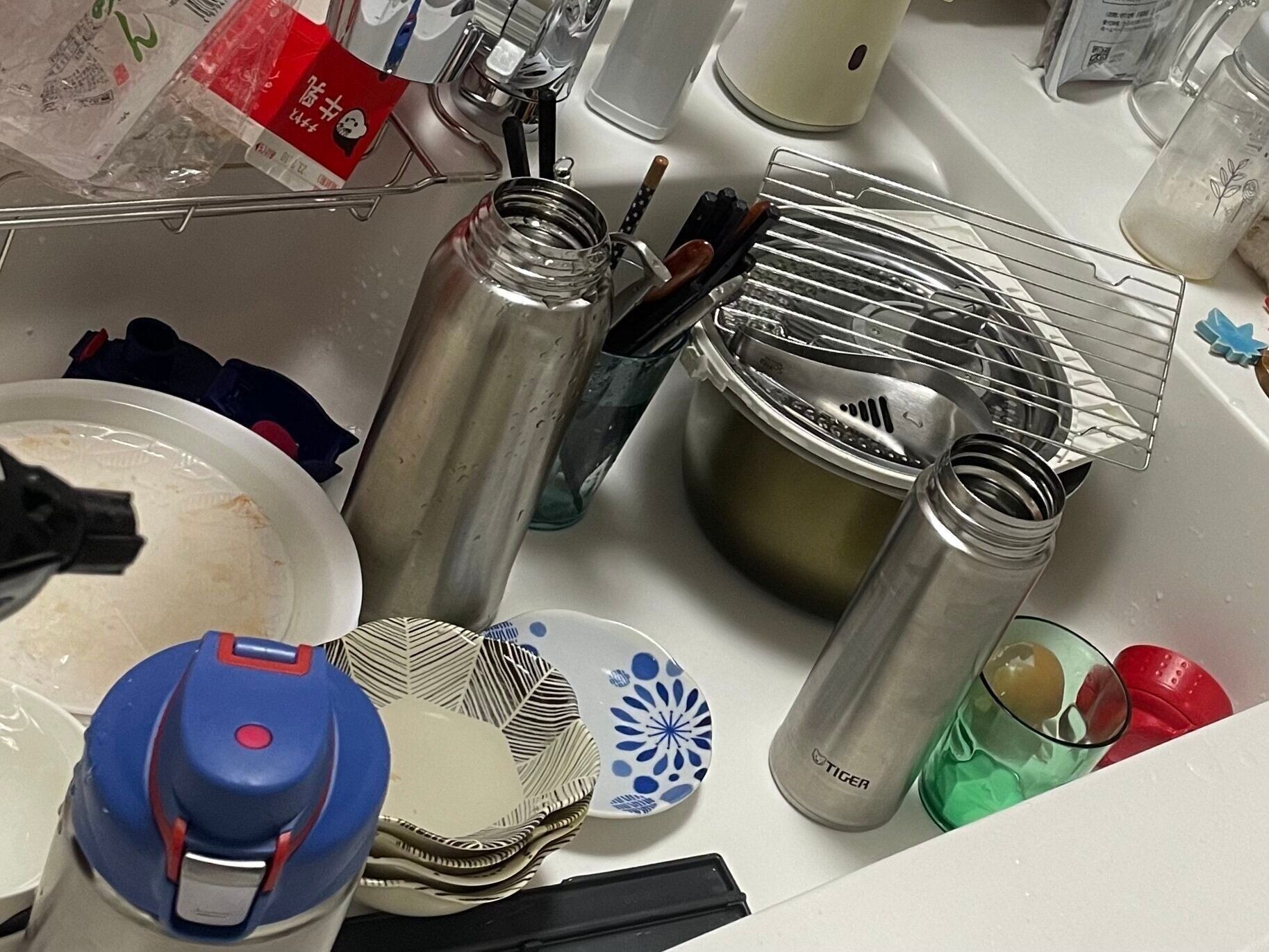 洗い物が溜まったキッチンのシンク