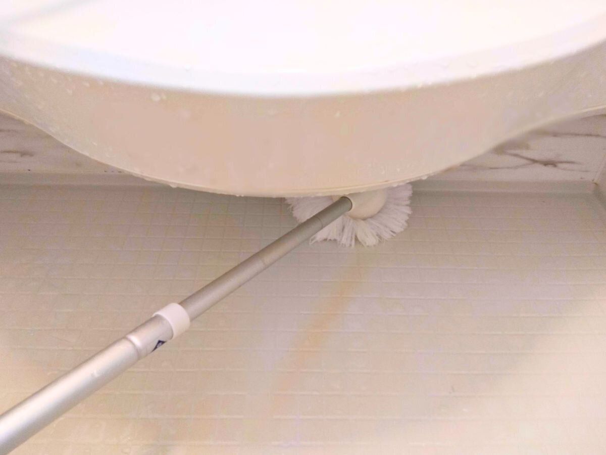 浴室のカウンター下をバスボンくんで掃除している画像
