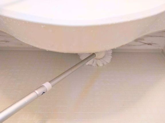 浴室のカウンター下をバスボンくんで掃除している画像
