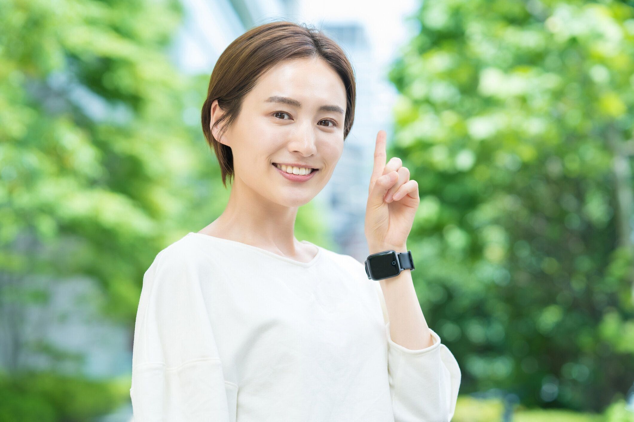 人差し指を立てるポーズをとる女性
