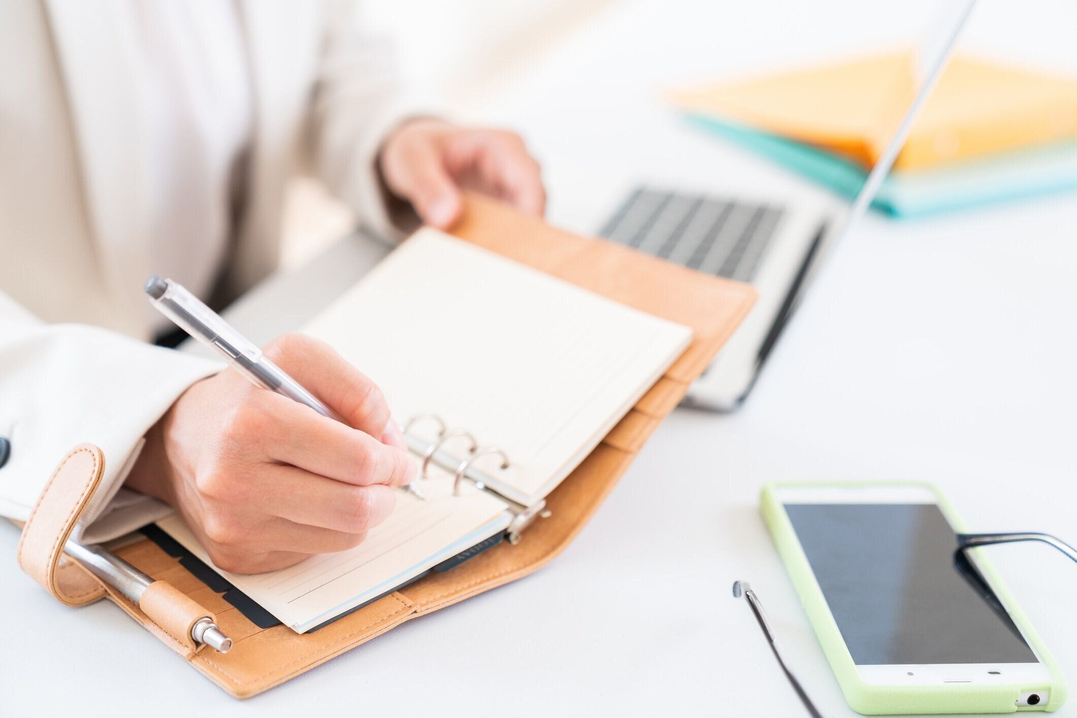 スケジュールブックに記入するアジア人女性、手