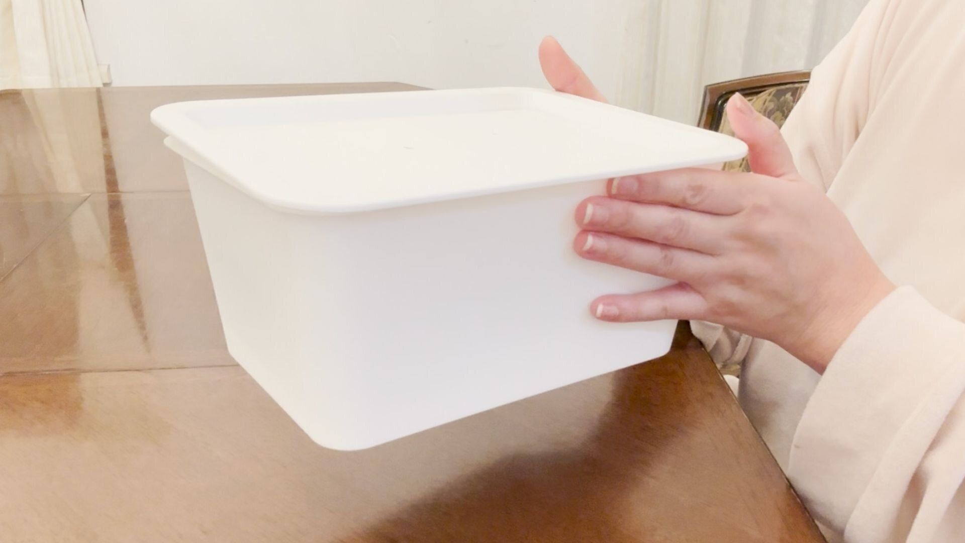 テーブルの上で収納ボックスを整える手元