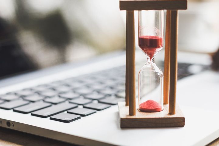 ラップトップ上のサンドクロックタイマー。時間のシンボル