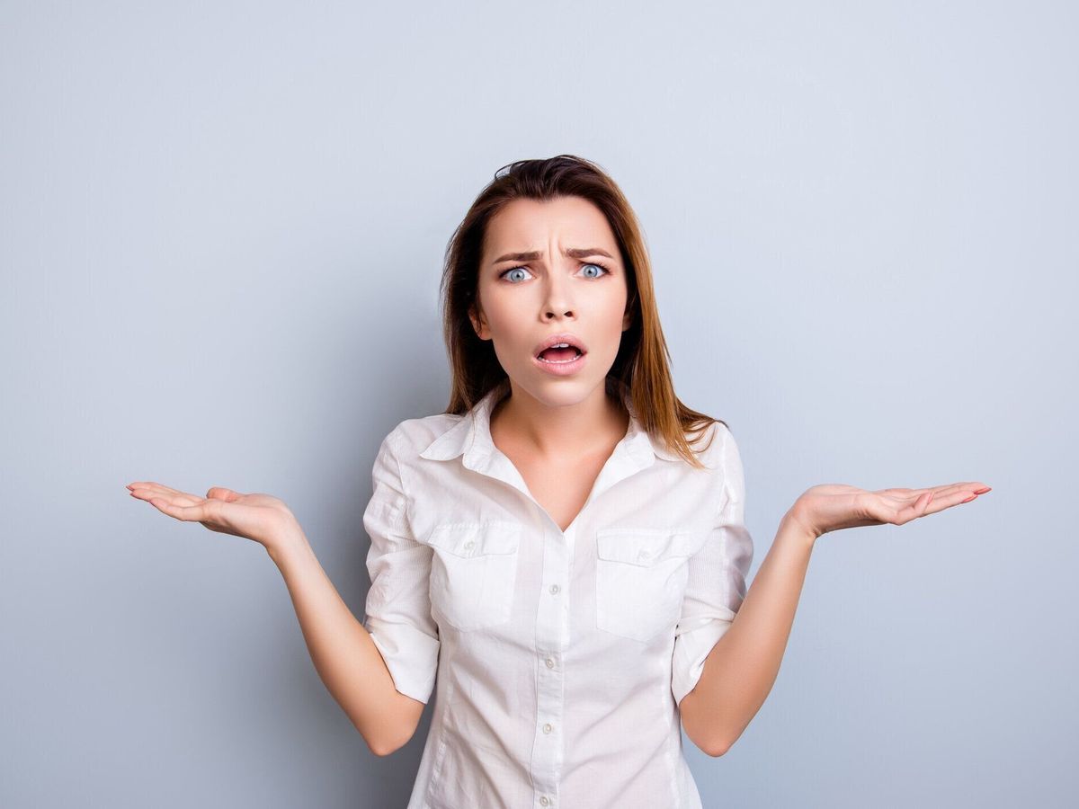 ほんとですか。!正式な摩耗でショックを受けたと不満の若い女性は驚いて、明るい背景に立っている分離コピー スペースを保持