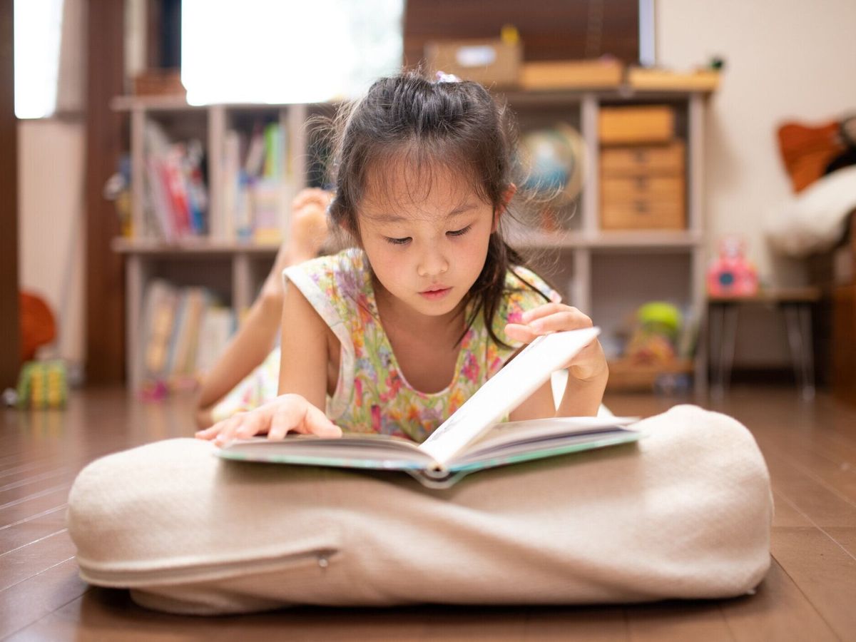 横になって本を読む女の子