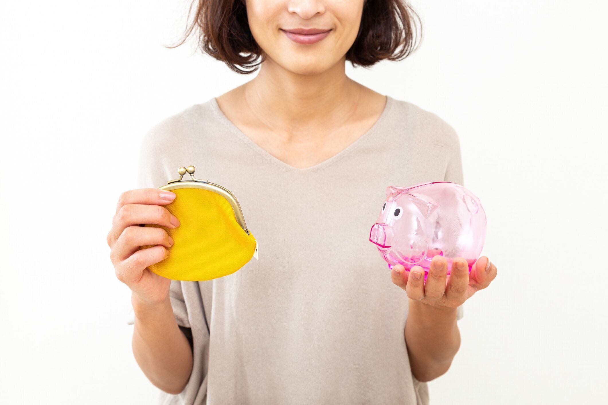 財布と貯金箱を持つ女性