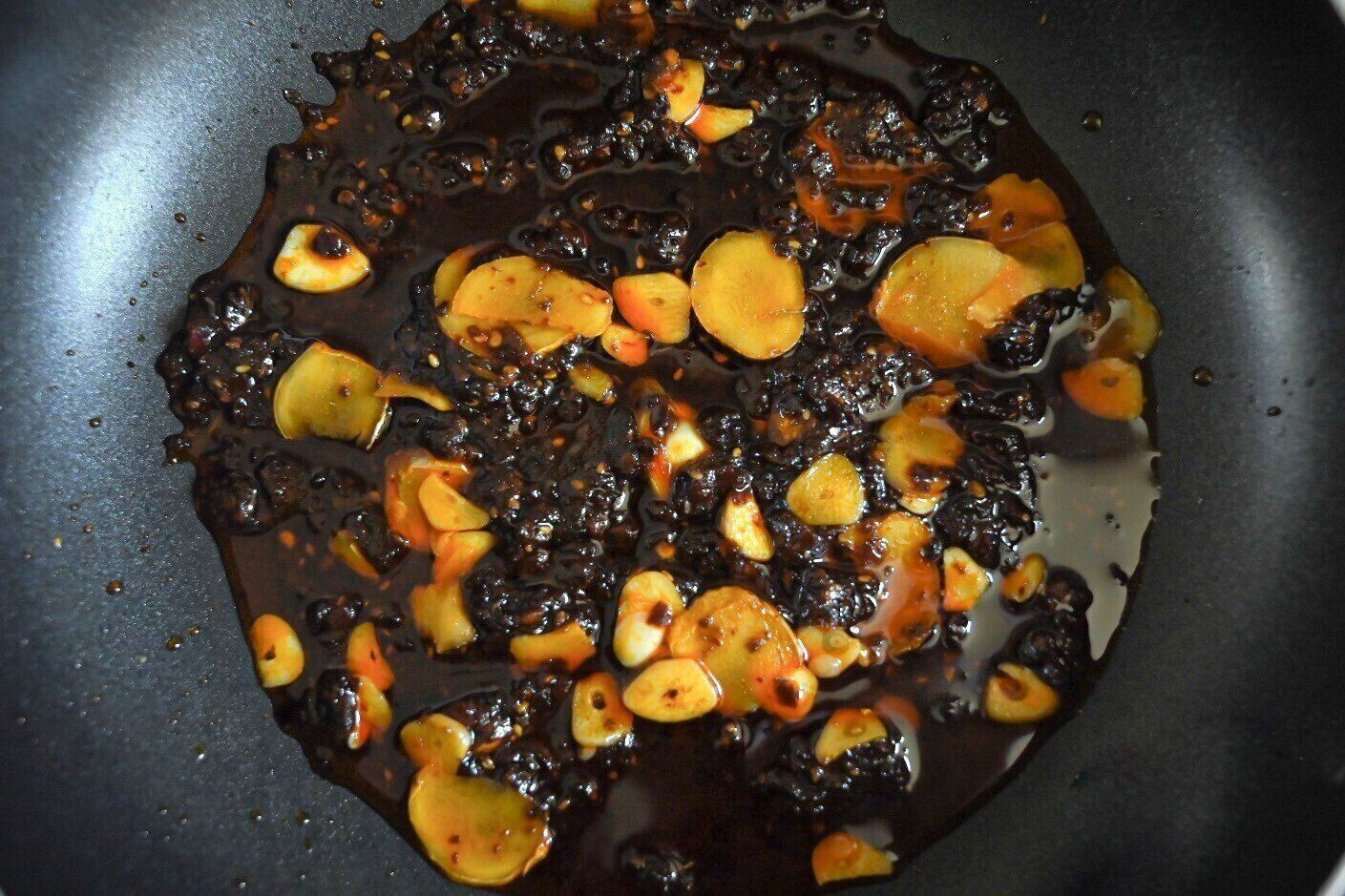 フライパンに入った麻辣香鍋の素と合わせたにんにくとしょうが